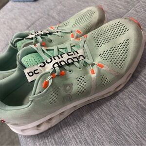On Running Light Green Athletic Shoes with Orange Highlights